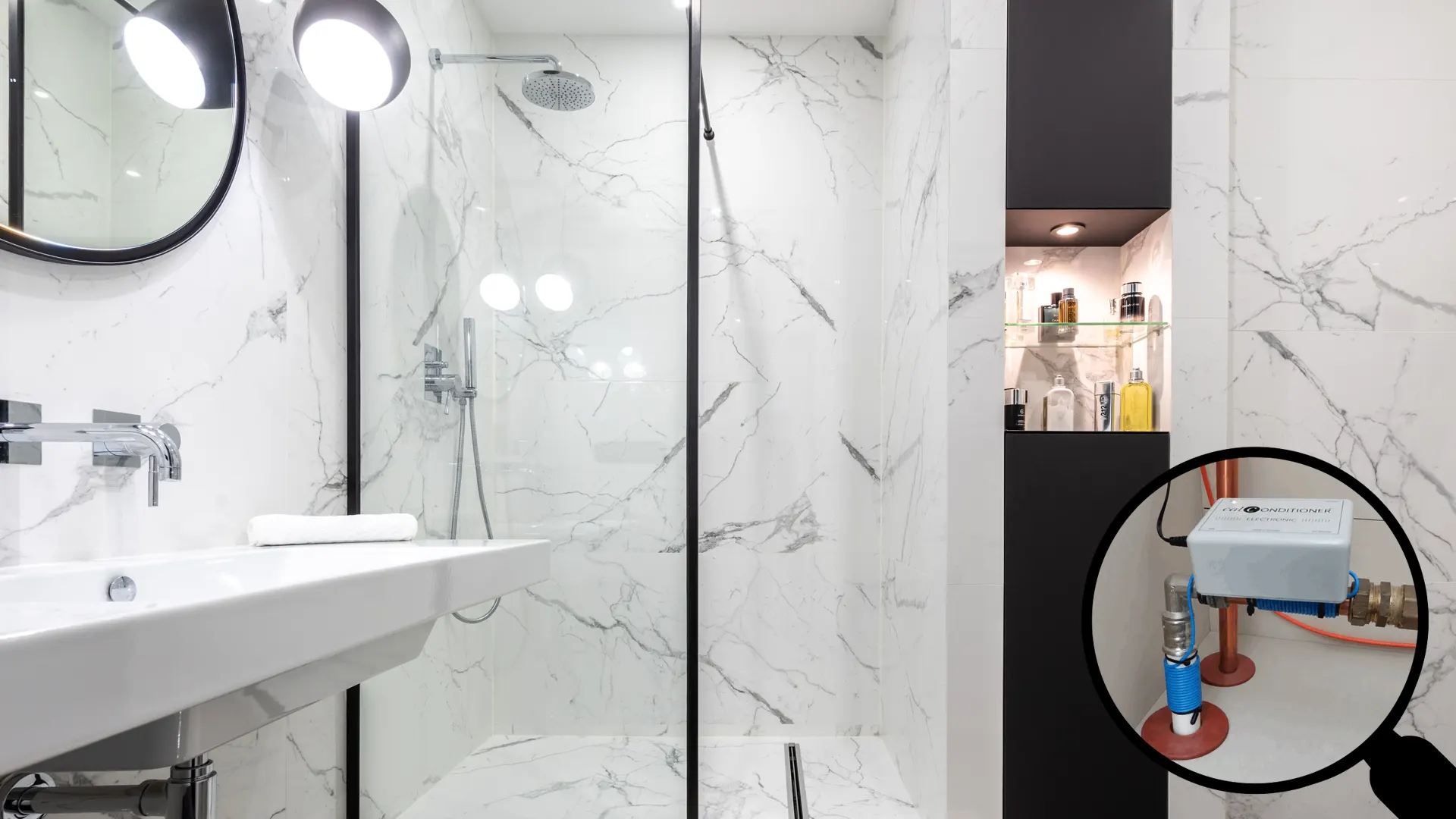 Baño moderno con mampara de cristal brillante sin cal y lupa mostrando el descalcificador ecológico Calconditioner instalado en la tubería.